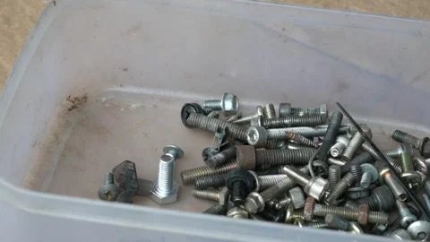 Hand Placing Mixed Screws, Bolts and Nuts into Plastic Container Stock Footage 336756640