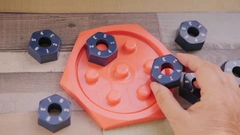 Hand placing numbered blue hexagonal puzzle pieces orange educational game .. Stock Footage 317700022