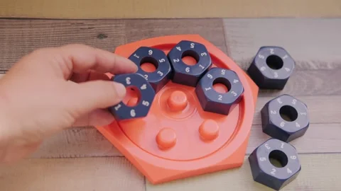 Hand placing numbered blue hexagonal puzzle pieces orange educational game .. Stock Footage 327742635