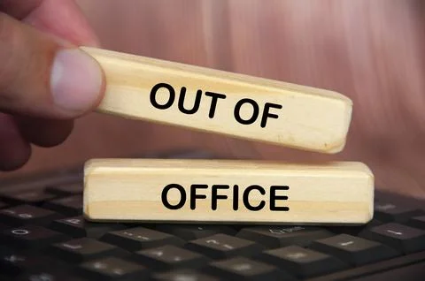 Hand placing out of office text on wooden blocks. Getaway or on a vacation .. Stock Photos