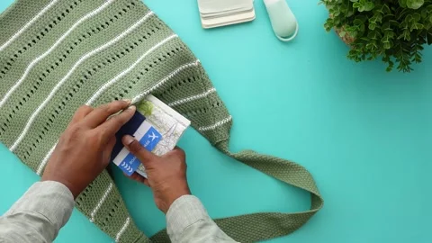 Hand placing passport and map into crochet bag, travel preparation, dynamic.. Stock Footage 332105294