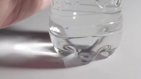 Hand Placing a Plastic Bottle of Water on a White Table, Close Up HD Stock Footage 318622261