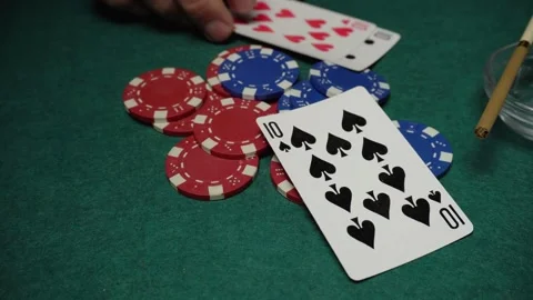 Hand placing playing cards on a stack of poker chips during a card game on a Stock Footage 336024620
