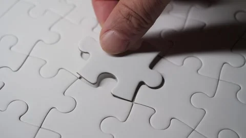 A hand placing a puzzle piece into its final spot, completing the jigsaw. 스톡 동영상 308771380