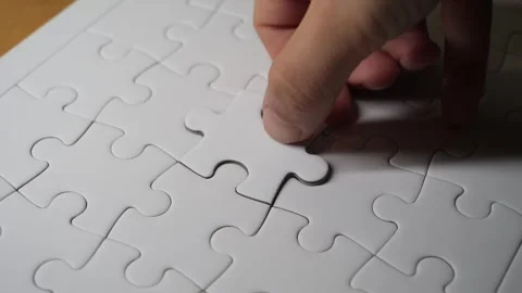 A hand placing a puzzle piece into its final spot, completing the jigsaw. 스톡 동영상 308771403