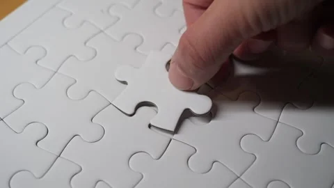 A hand placing a puzzle piece into its final spot, completing the jigsaw. 스톡 동영상 308771466