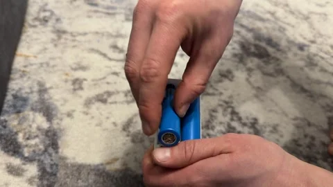 Hand placing rechargeable batteries into charger, household battery charging Stock Footage 337121237