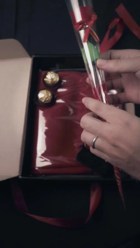 Hand Placing Red Rose in Romantic Gift Box with Chocolate Stock Footage 322606569