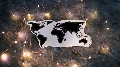 Hand placing Reopening text on world map surrounded by fairy lights shot at s Stock Footage 131503373