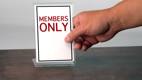 A hand is placing a sign for members only on a wooden table. Stock Footage 314575606
