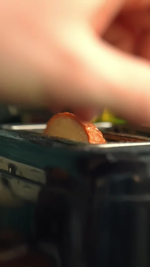 Hand placing a slice of bread into a toaster in a kitchen, close-up food prep Stock Footage 332068203