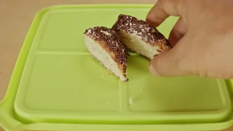 Hand placing soft cake slices with abundant chocolate sprinkles on a light .. Video stock 324820343