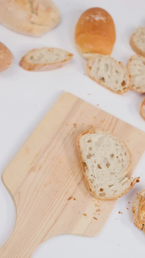 Hand Placing Sourdough Bread and Butter on Wooden Cutting Board Vídeo Stock 337521256