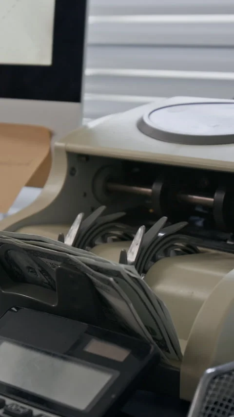 Hand Placing Stack of Hundred-Dollar Bills into Machine 库存影片 330962163