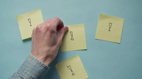 Hand placing sticky note on blue paper backdrop Stock Footage 320557692