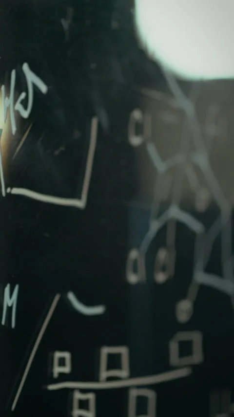 Hand placing sticky note on a chalkboard in a learning environment 動画素材 331595785