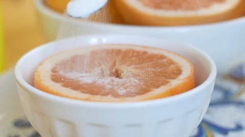 Hand placing sugar on a grapefruit Stock Footage 117541238