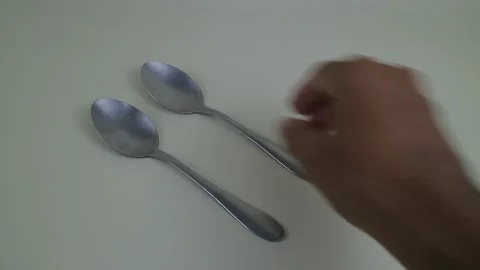 Hand Placing Three Stainless Steel Spoons on Table Surface Stock Footage 333240675