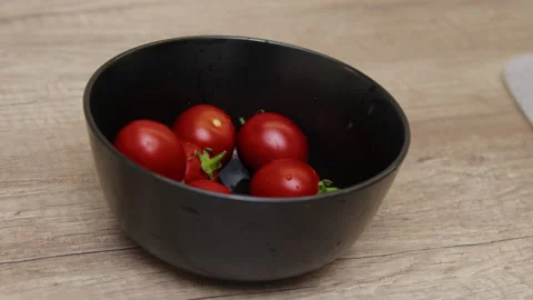 A hand placing tomatoes into a bowl. Stock Footage 266427353
