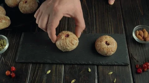 Hand placing traditional baked sweets on a slate serving board, with additional Stock Footage 336870829