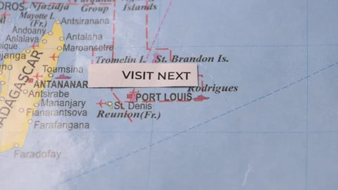 Hand placing visit next label on map pointing to Mauritius travel destination Stock Footage 346577620