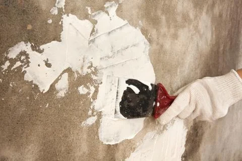 Hand plastering surface of wall with spatula Stock Photos