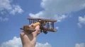 The hand play with a wooden plane on the background of a cloud 4k or 4k+ Resolution
