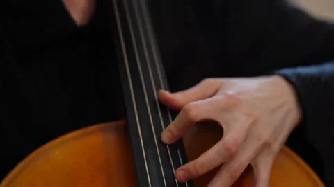 Hand playing cello strings in close up 库存影片 347813778