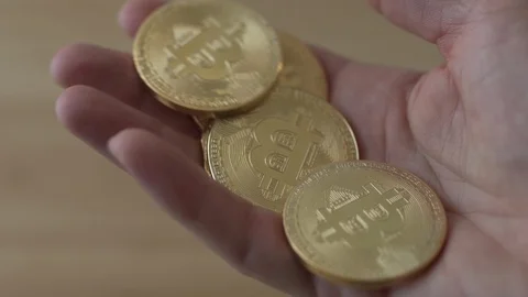 A hand playing with a handful of Bitcoin cryptocurrency coins Video stock 85749607