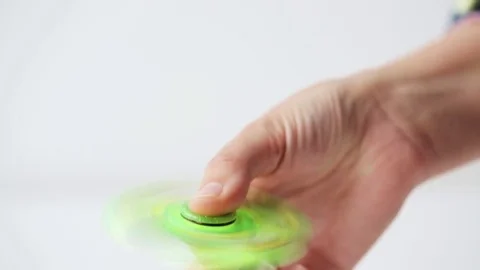 Hand playing with spinning fidget spinner Stock Footage