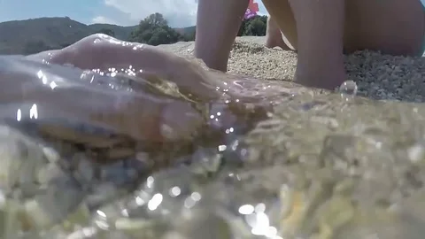 Hand playing in water with feet Stock Footage 81589110