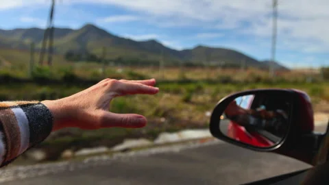 Hand Playing in the Wind Through Car Window on Road Trip Stock Footage 313086628