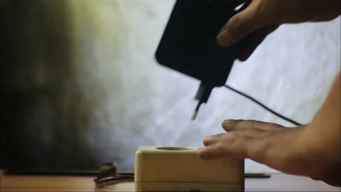 Hand plug black notebook charger adapter into power socket close-up view. Stock Footage 181926546
