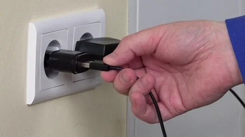 Hand plug charger adapter into wall socket. Stock Footage 82575850