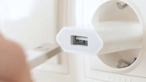 Hand plug usb charger adapter and wire into wall socket. Stock Footage 80593528