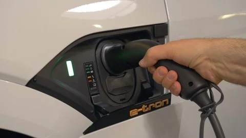Hand plugging and unplugging the charger of an Audi e-tron electric vehicle Stock Footage 105672201
