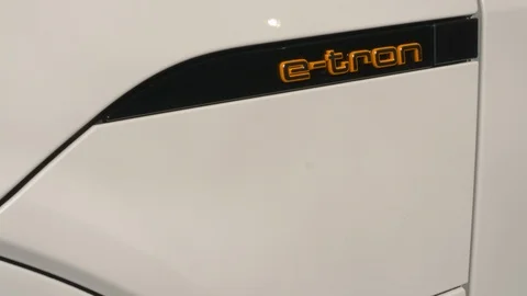 Hand plugging and unplugging the charger of an Audi e-tron electric vehicle Stock Footage 105679219