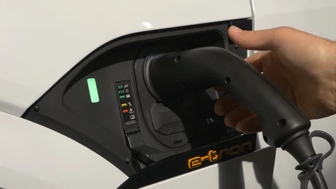 Hand plugging and unplugging the charger of an Audi e-tron electric vehicle Stock Footage 105679800
