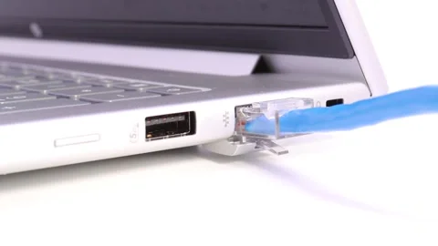 Hand plugging blue lan cable into laptop ethernet port Stock Footage 329010055