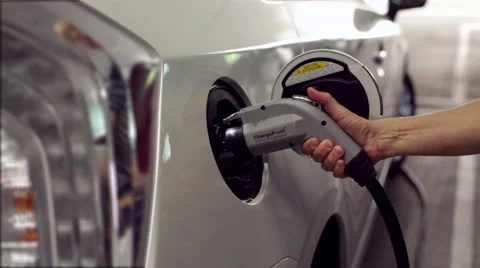 Hand Plugging in Cable to Recharge Electric Vehicle Stock Footage 49784544