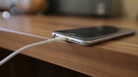 Hand plugging the charger into cell phone. USB data cable connecting to gadget Stock Footage 72624805