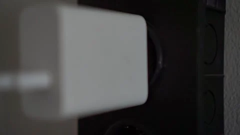 Hand plugging in charger to electrical outlet, close up view, power connection Video stock 344011377