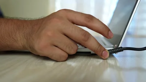 Hand Plugging Charger into Laptop, Close-up of a hand plugging a charger in.. Stock Footage 317736784