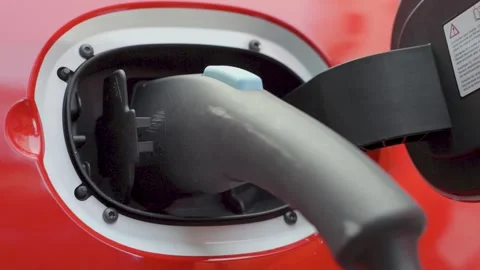 Hand Plugging Electric Car Charger Into Vehicle Socket in Close Up View Stock Footage 334054011