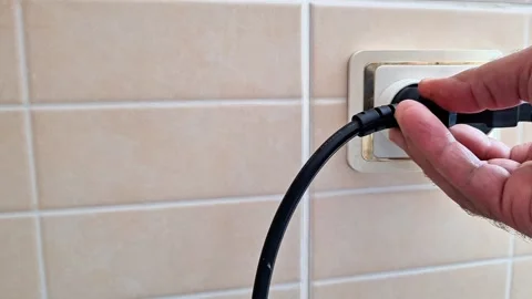 Hand Plugging Electrical Power Cord into Wall Socket Close Up Stock Footage 340121797