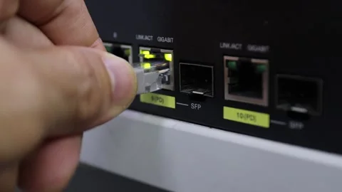 Hand plugging an Ethernet cable into a network switch port Stock Footage 327101100