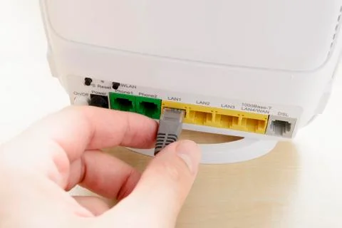 Hand Plugging an Ethernet Cable Into a Wifi Router Stock Photos