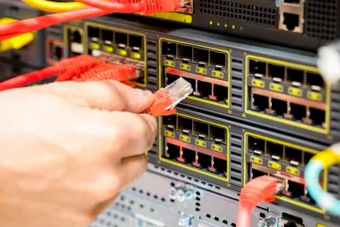 Hand Plugging Fiber Cable Into Switch In Datacenter Stock Photos