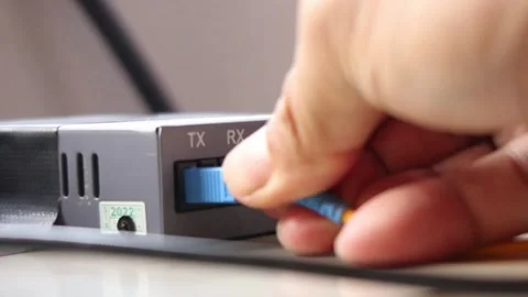 Hand plugging fiber optic cable connector into terminal device Stock Footage 291595543