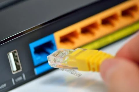 Hand plugging in internet modem cables Stock Photos